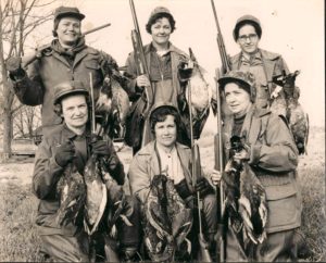 A group of women holding guns and ducks.