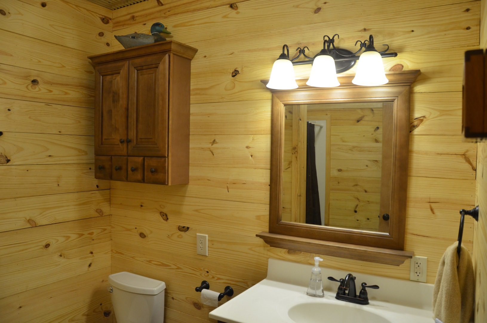 A bathroom with wood paneling and a white sink.