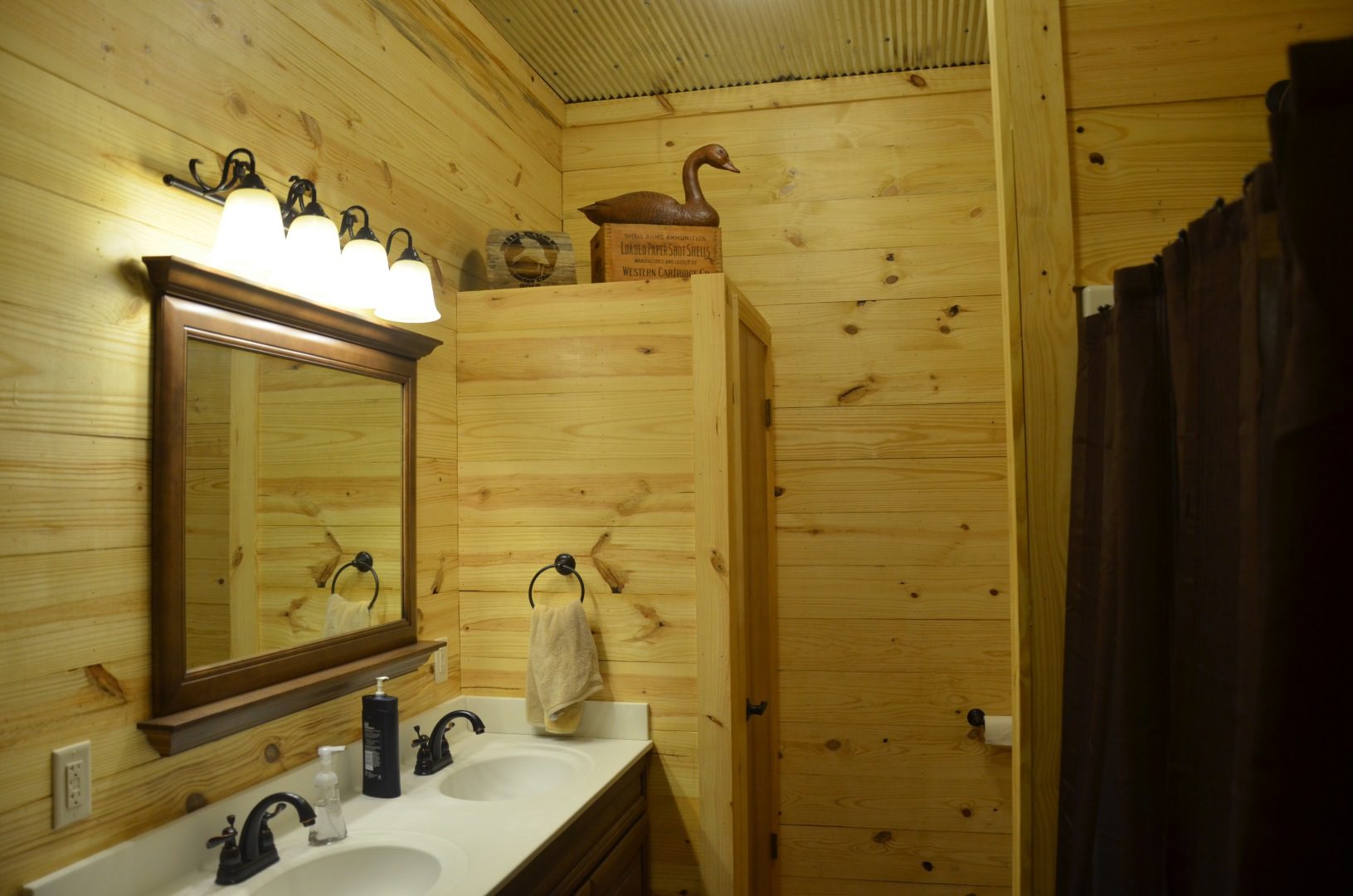 A bathroom with wooden walls and white fixtures.