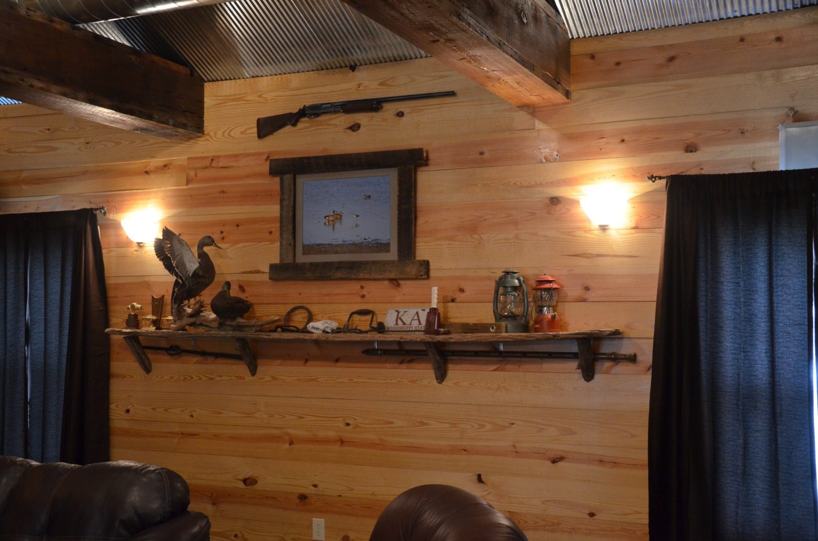 A gun rack and shelf in the corner of a room.